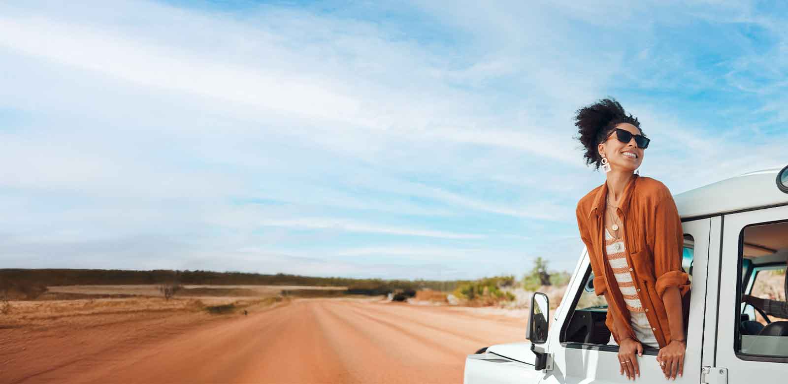 woman hanging outside of car window smiling.