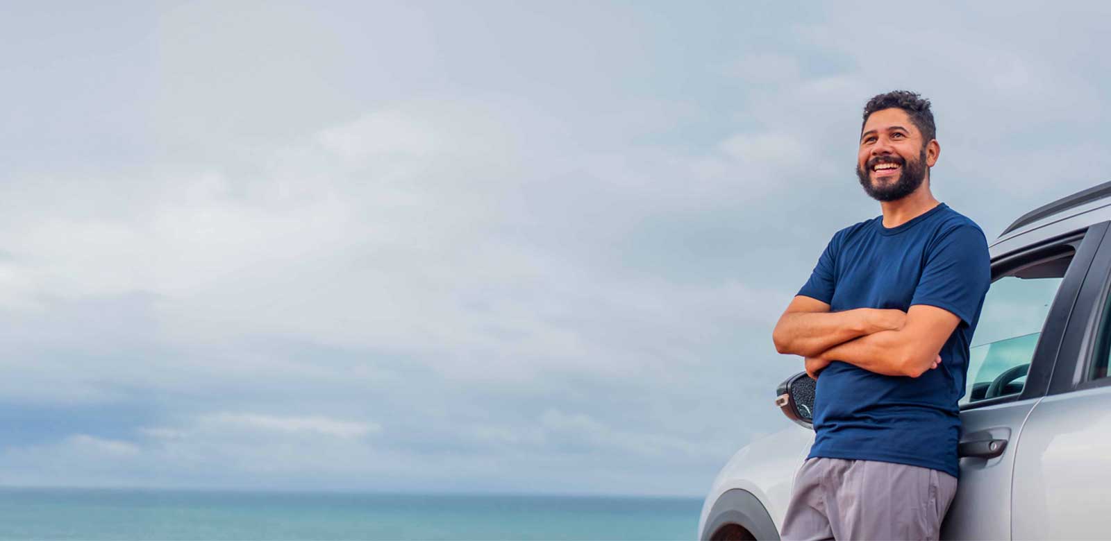 Man leaning on a car smiling